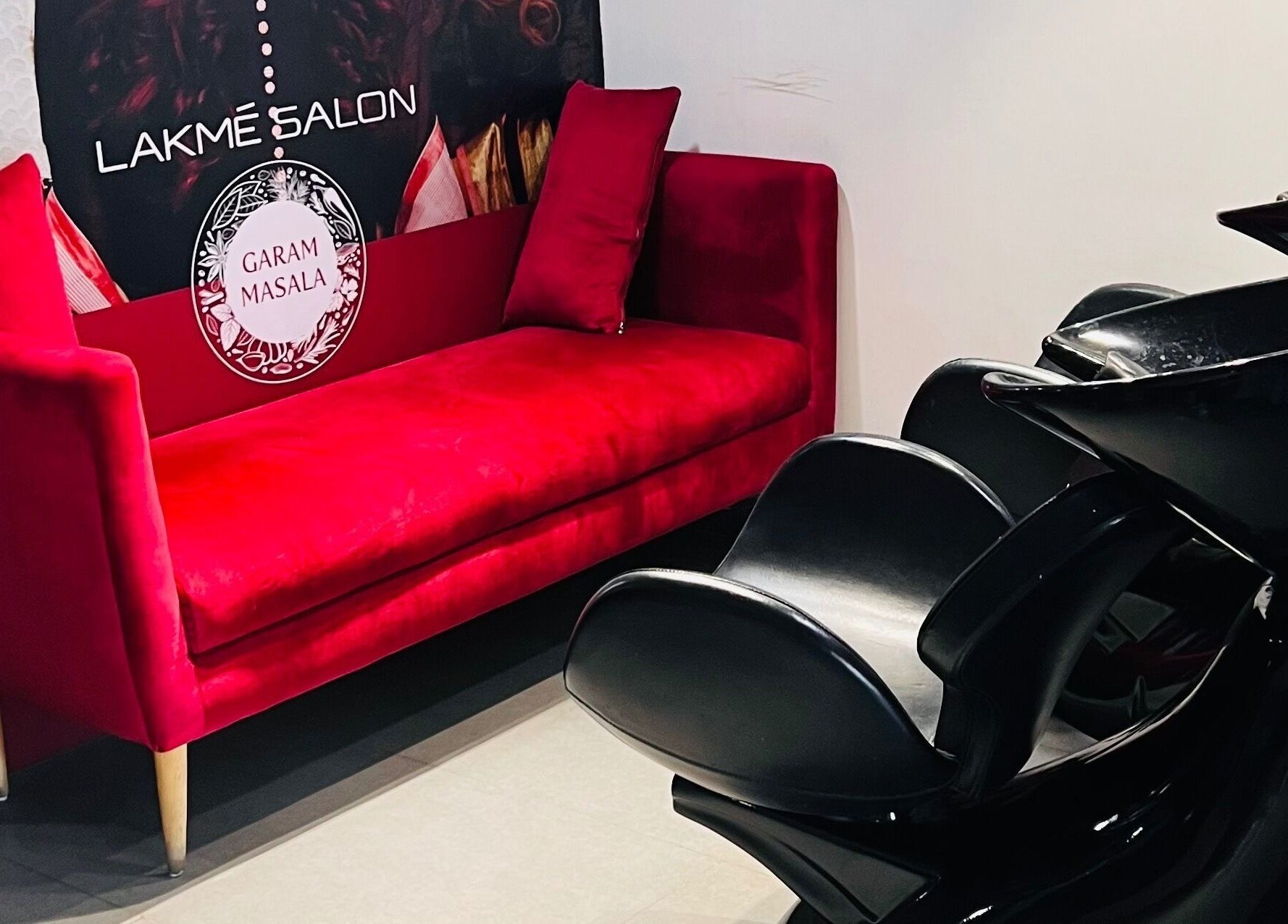 Red couch and black chairs at Lakme Salon Kompally, Hyderabad, Telangana, IN showcase elegant salon setting.