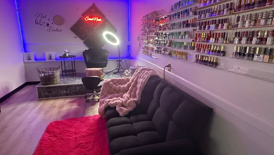 Sarai Nails salon in Columbus, Ohio, US, showcasing plush seating and nail polish display under ambient lighting.