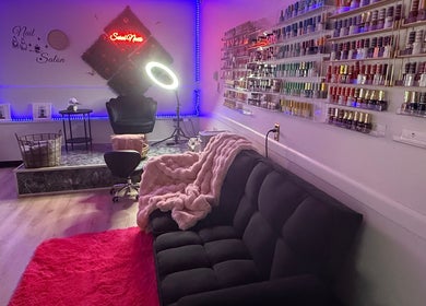 Sarai Nails salon in Columbus, Ohio, US, showcasing plush seating and nail polish display under ambient lighting.