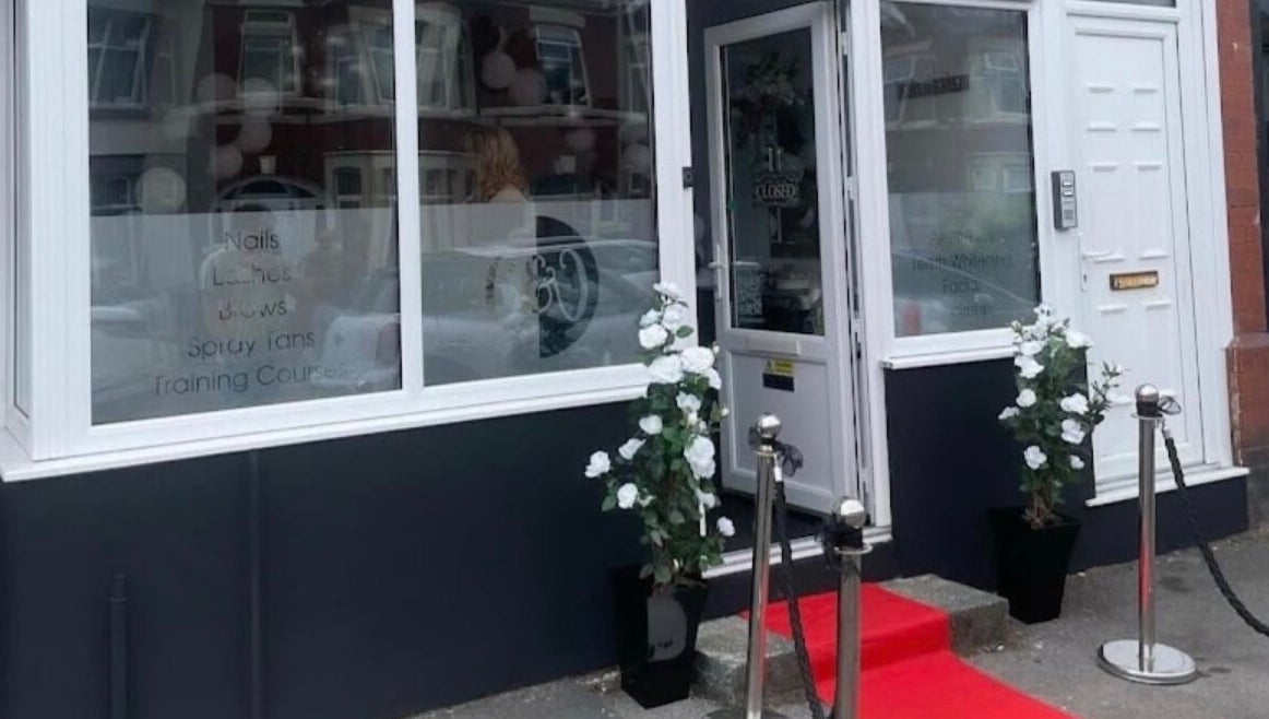 Front entrance of The Glow Up in Blackpool, England, GB with red carpet and floral decor.