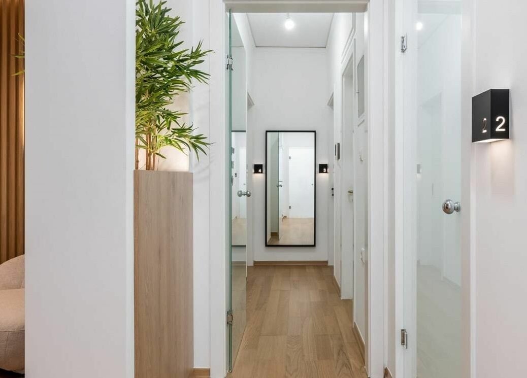 Κομψός εσωτερικός χώρος εισόδου στο Pure, Κορωπί, GR, με φυσικό φωτισμό και μοντέρνα διακόσμηση.