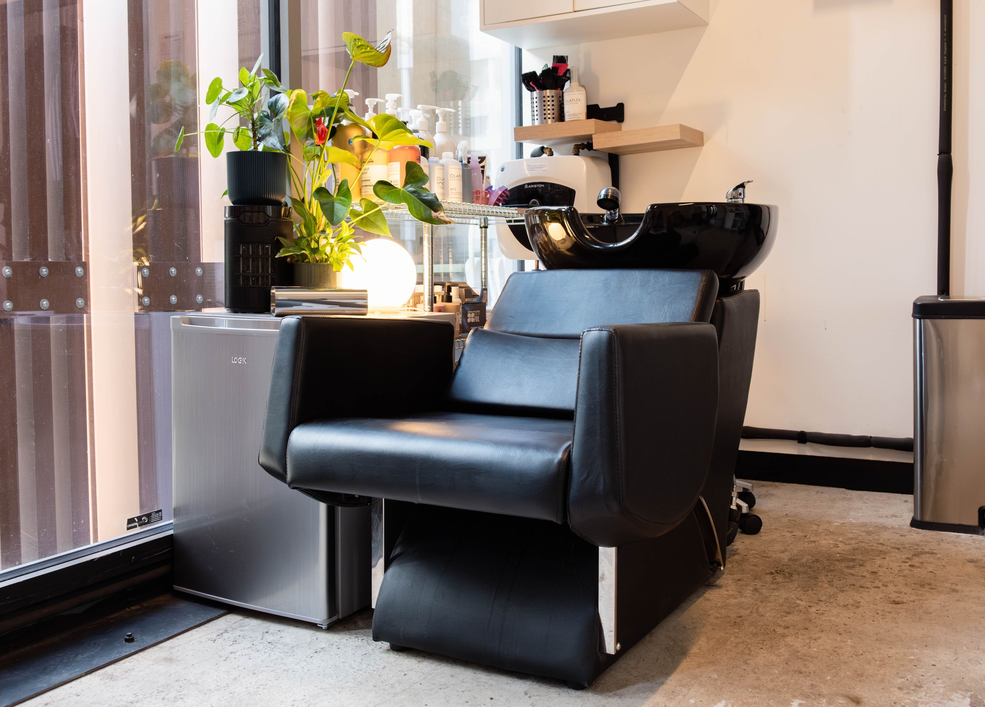 Stylish salon chair at SPACE5, London, GB with modern decor and lush plant accents.
