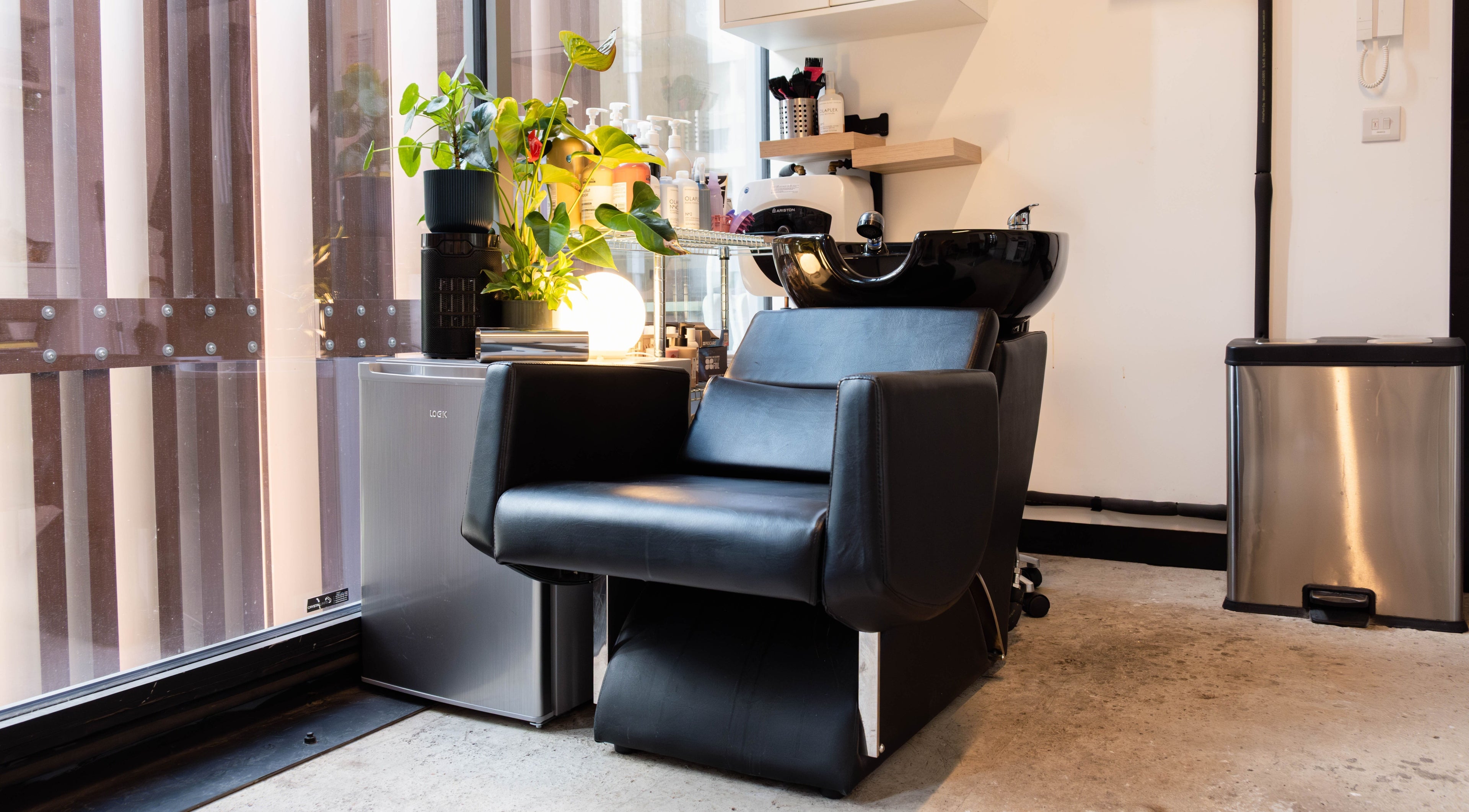 Stylish salon chair at SPACE5, London, GB with modern decor and lush plant accents.