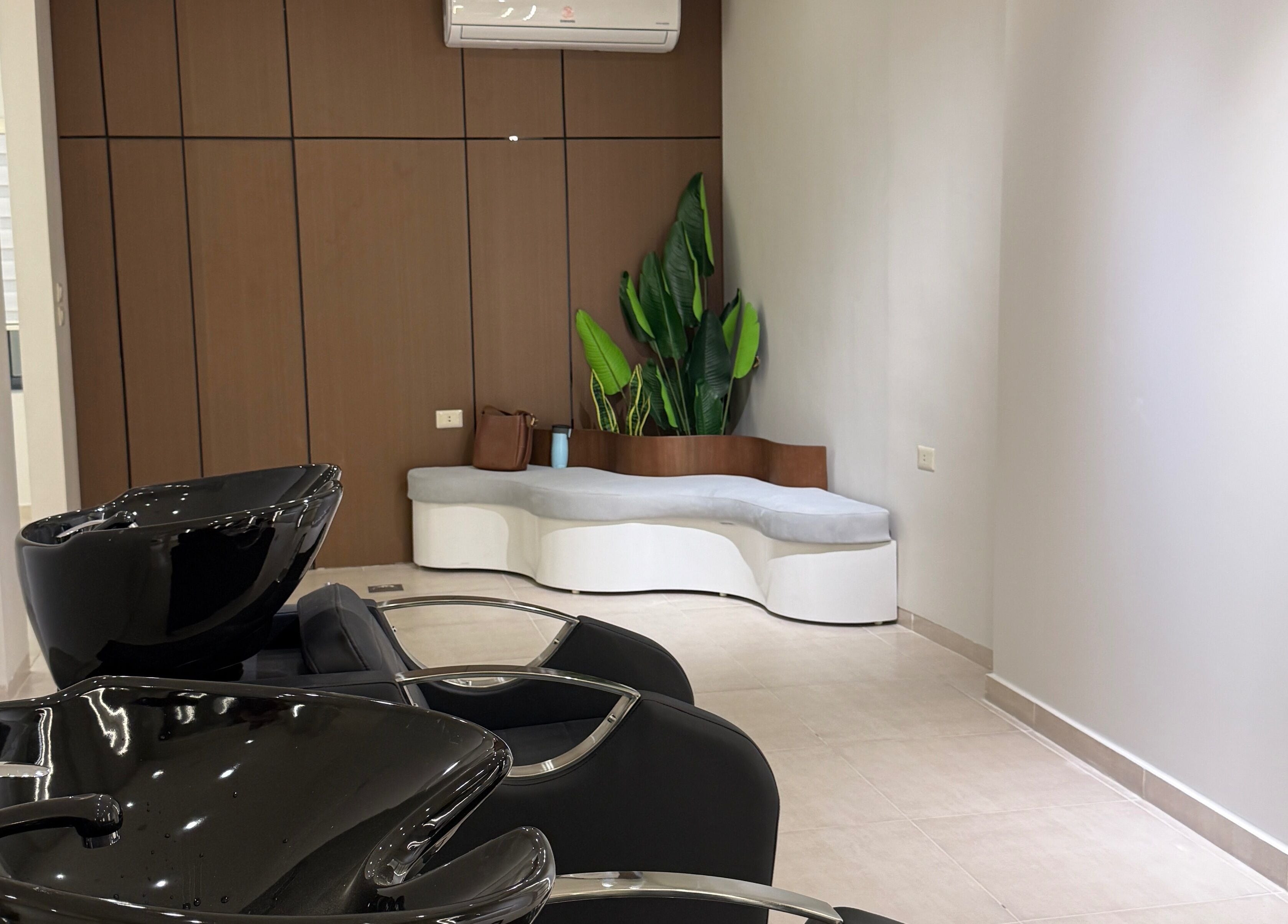 Modern shampoo area with stylish black basins at Curlz Beauty Center - Irbid, Irbid Governorate, JO.