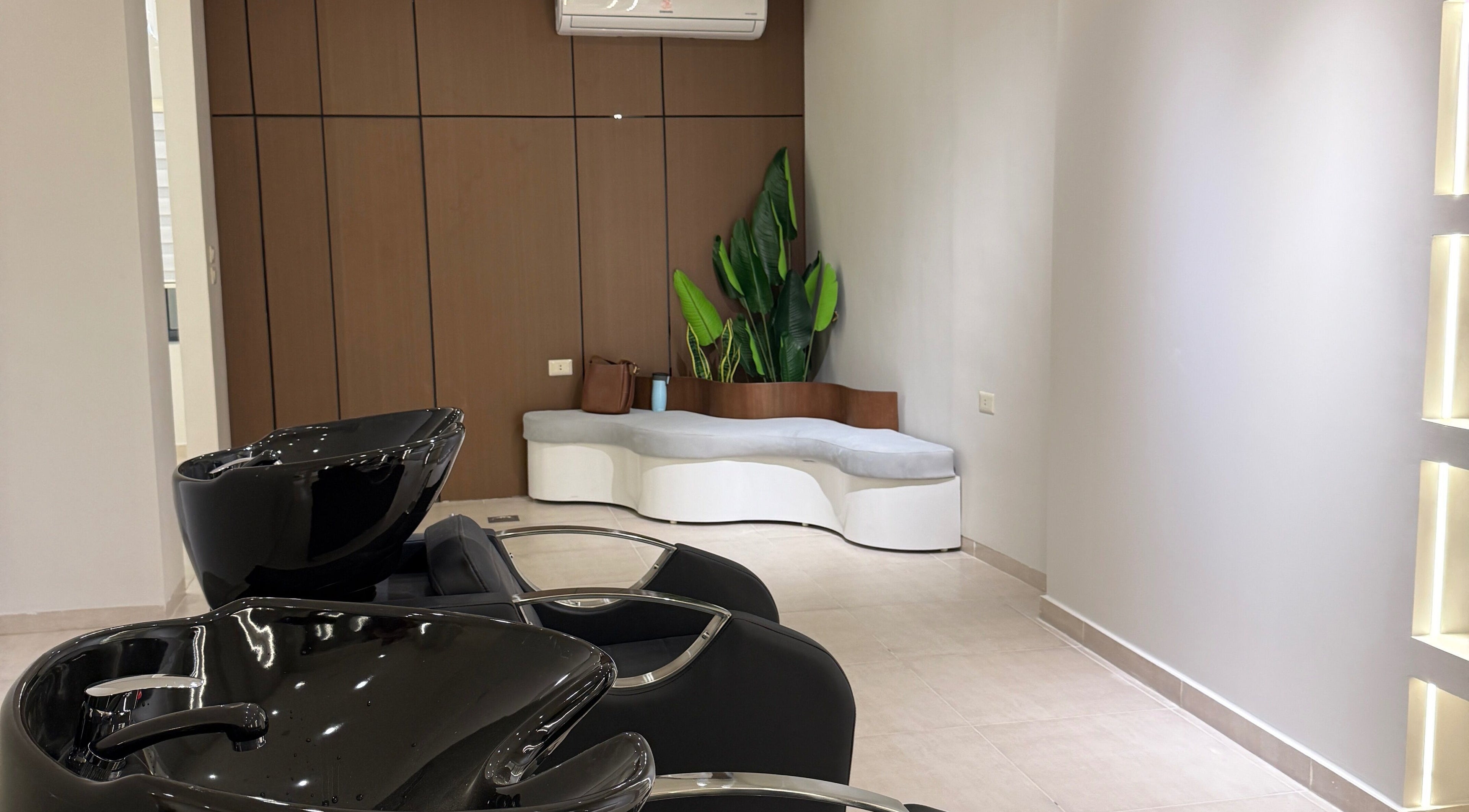 Modern shampoo area with stylish black basins at Curlz Beauty Center - Irbid, Irbid Governorate, JO.