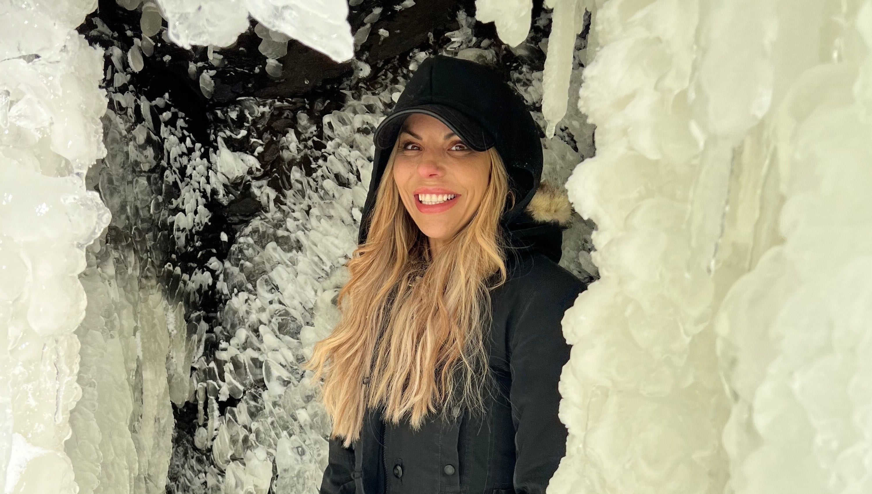Smiling woman amidst icy formations near Orillia & Area Luxury Extension Beauty Bar, Orillia, Ontario, CA.