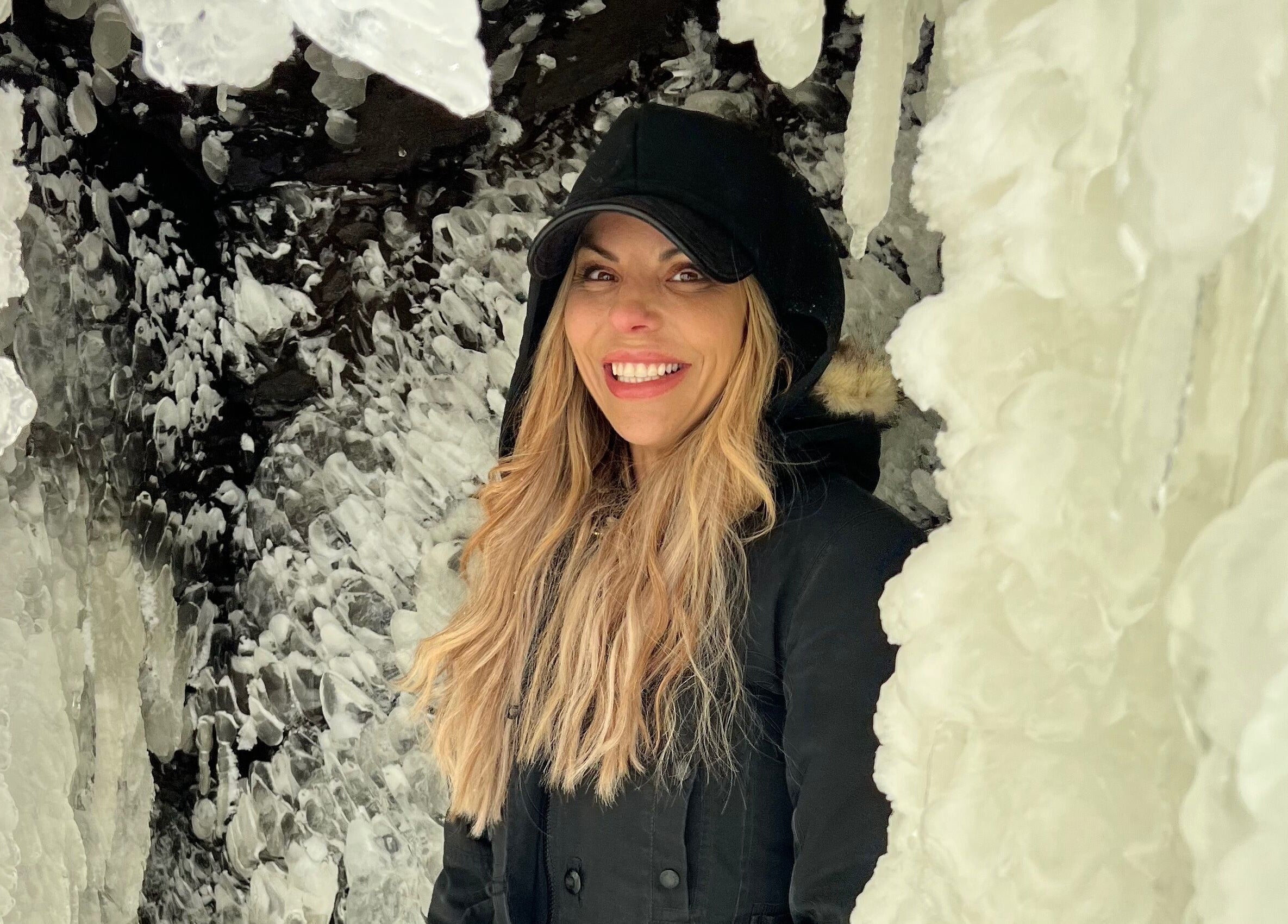 Smiling woman amidst icy formations near Orillia & Area Luxury Extension Beauty Bar, Orillia, Ontario, CA.