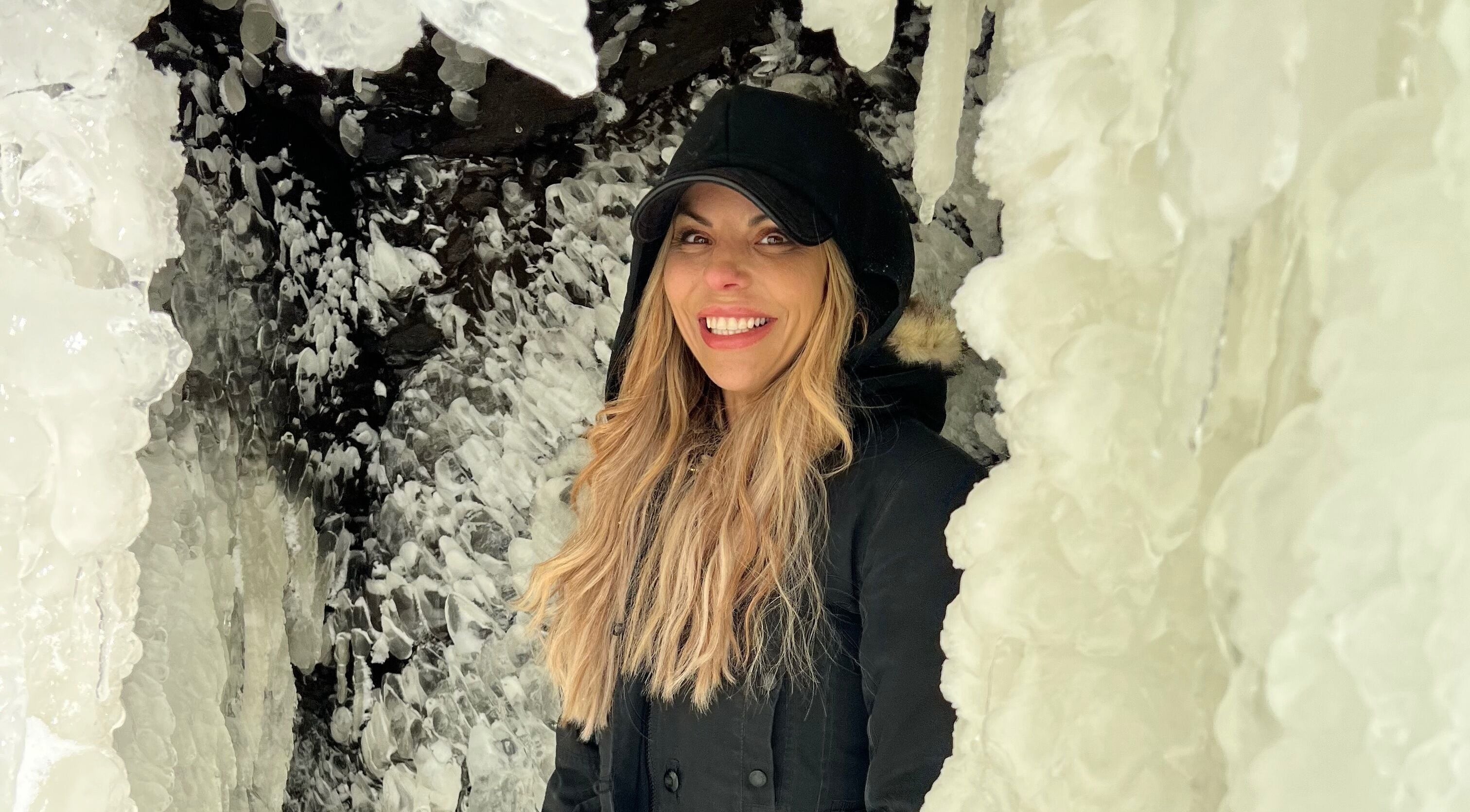 Smiling woman amidst icy formations near Orillia & Area Luxury Extension Beauty Bar, Orillia, Ontario, CA.