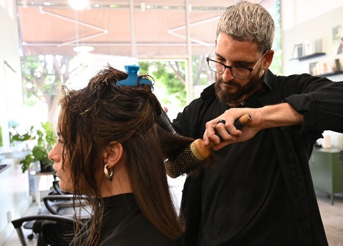 Expert stylist at Birdhaven Studio in Johannesburg, Gauteng, ZA, blow-drying a client's hair with precision.