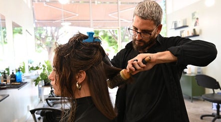 Expert stylist at Birdhaven Studio in Johannesburg, Gauteng, ZA, blow-drying a client's hair with precision.