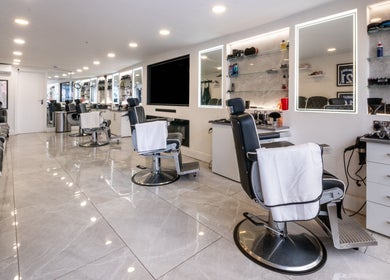 Interior of Grays Grooming For Men in Ewell, England, GB featuring modern barber chairs and mirrors.
