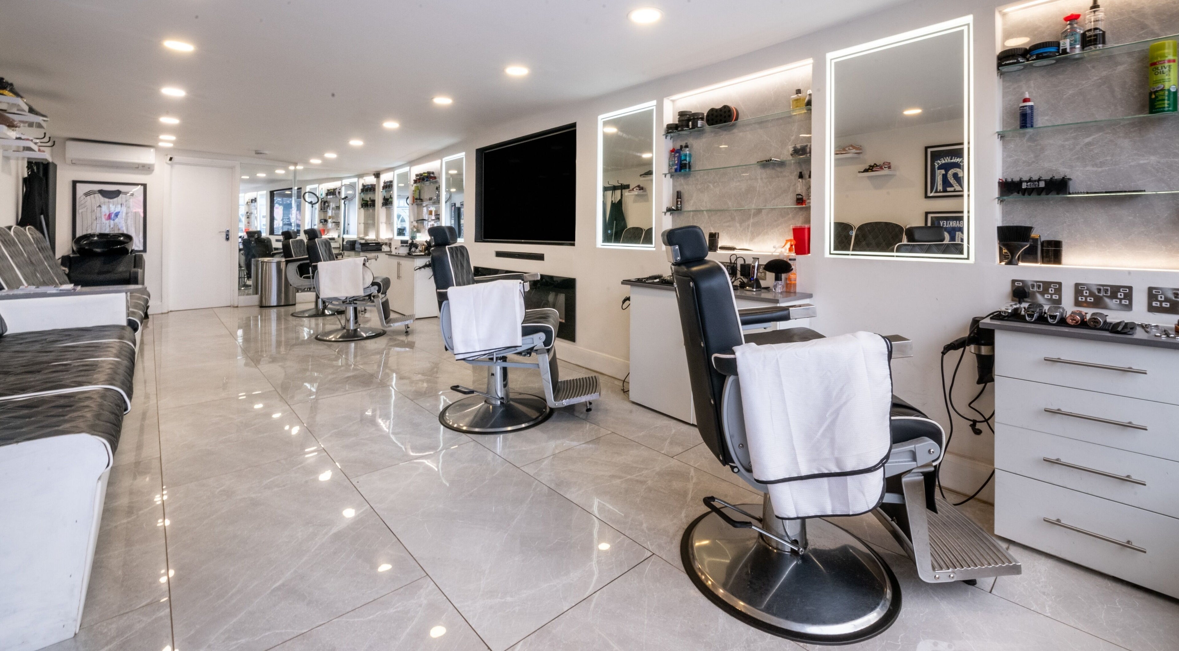 Interior of Grays Grooming For Men in Ewell, England, GB featuring modern barber chairs and mirrors.