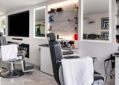 Modern barber chairs at Grays Grooming For Men, Ewell, England, GB showcasing sleek interior.