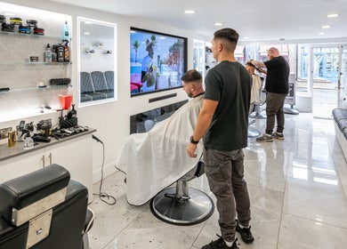 Interior of Grays Grooming For Men in Ewell, England, GB showing stylish barber chairs and grooming products.