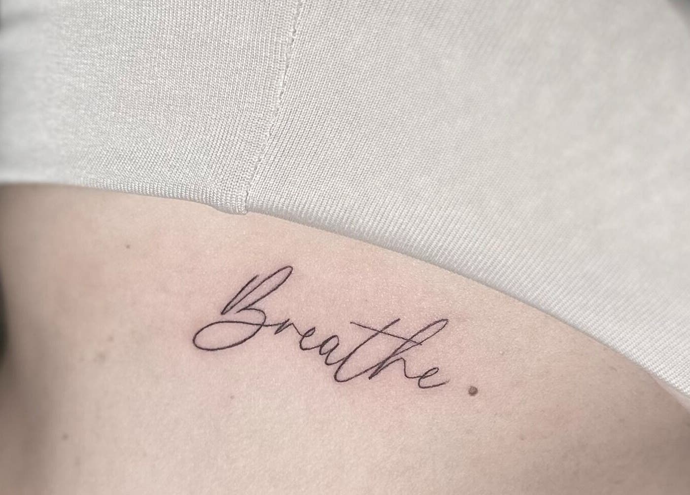 Elegant 'Breathe' tattoo at Nataly at Meadow & Charm - Council Bluffs, Iowa, US, enhancing personal expression.
