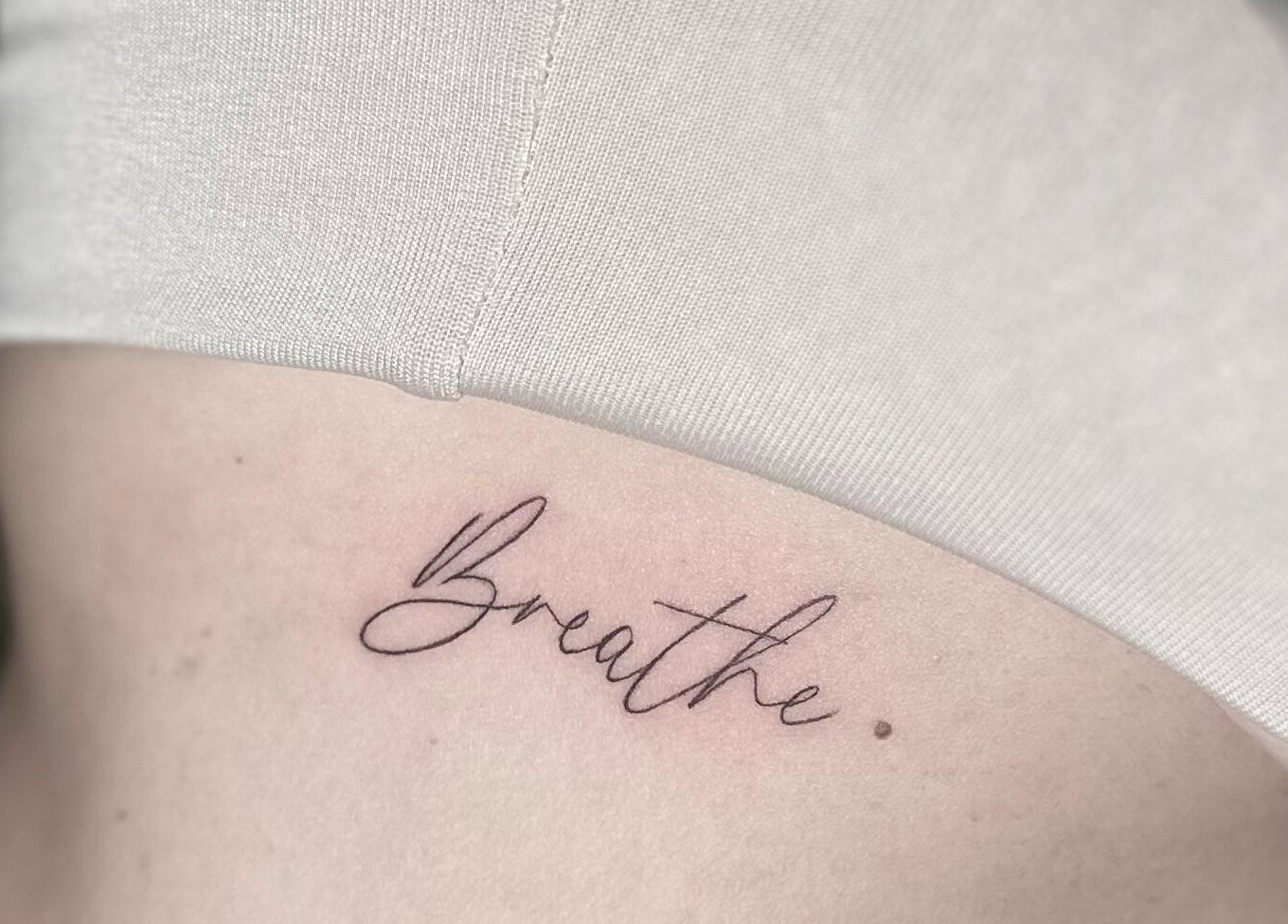 Elegant 'Breathe' tattoo at Nataly at Meadow & Charm - Council Bluffs, Iowa, US, enhancing personal expression.