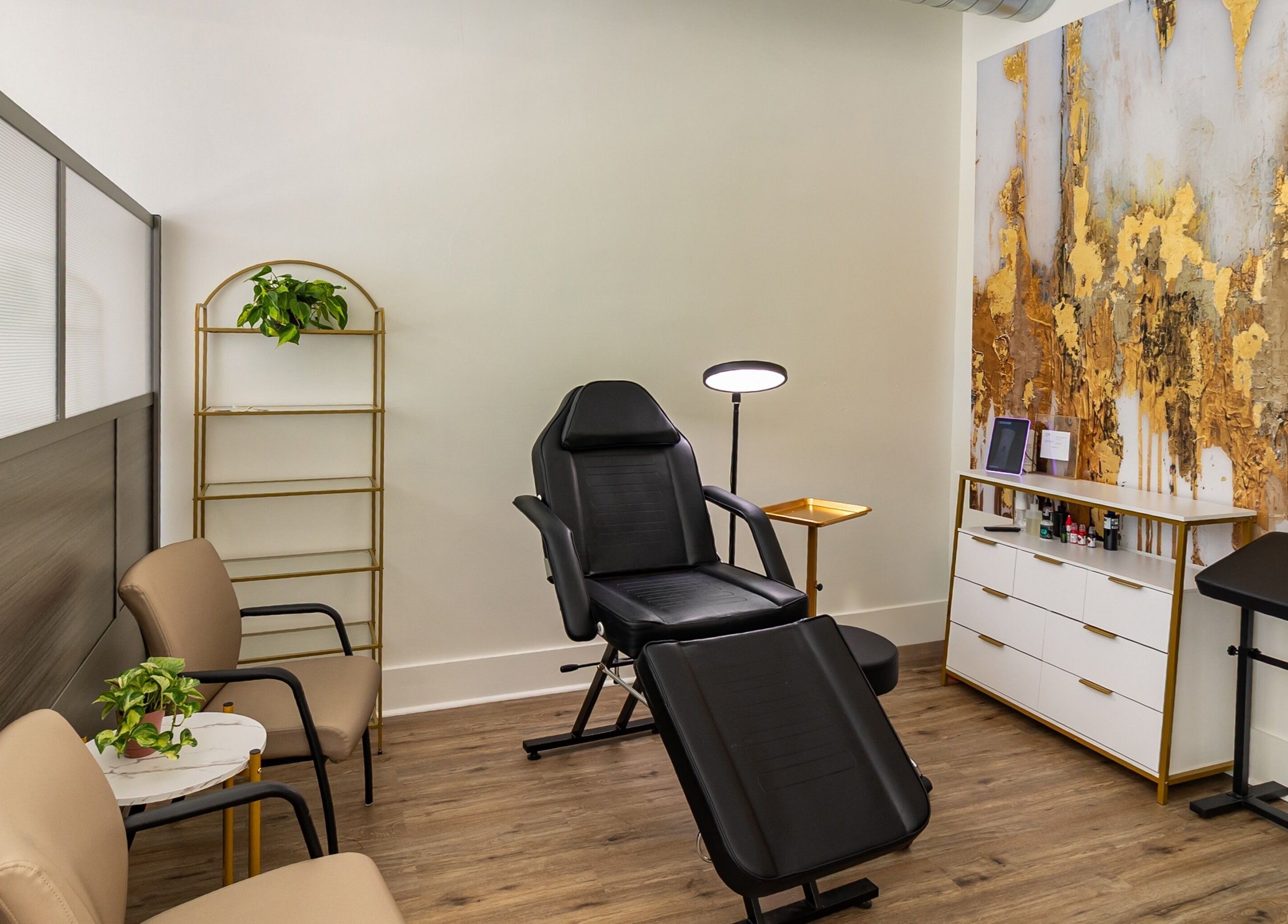 Comfortable treatment room at Meadow & Charm - Council Bluffs, adorned with gold art in Council Bluffs, Iowa, US.