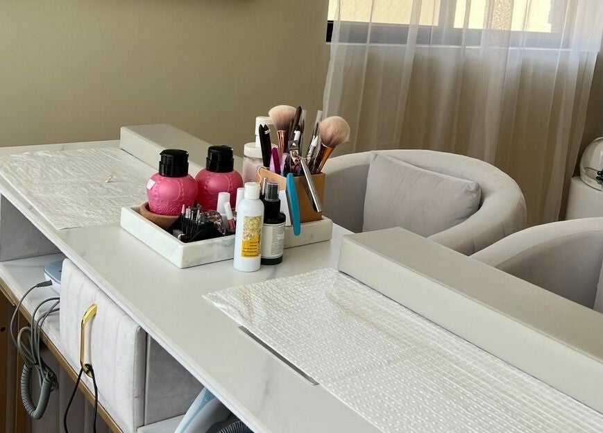 Chic beauty station at Queen Bee Aesthetic, Robertson, Queensland, AU, featuring elegant seating and nail care essentials.