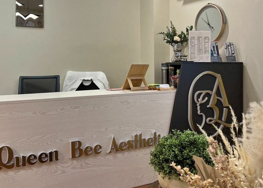 Stylish reception desk at Queen Bee Aesthetic, Robertson, Queensland, AU with elegant decor and signage.