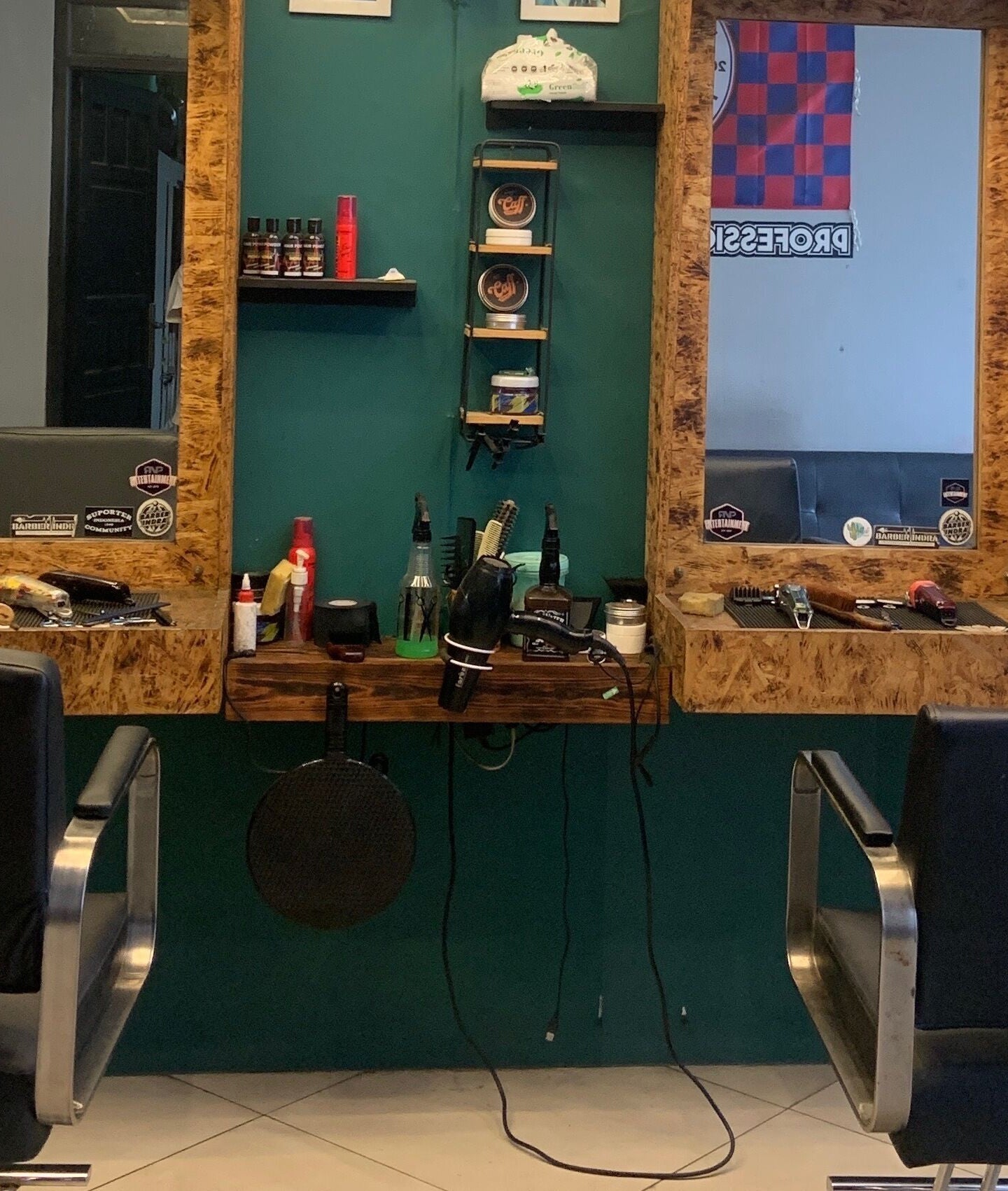 Modern cutting station at Indra Barbershop, Jawa Barat, Jawa Barat, ID with sleek black chairs and grooming tools.