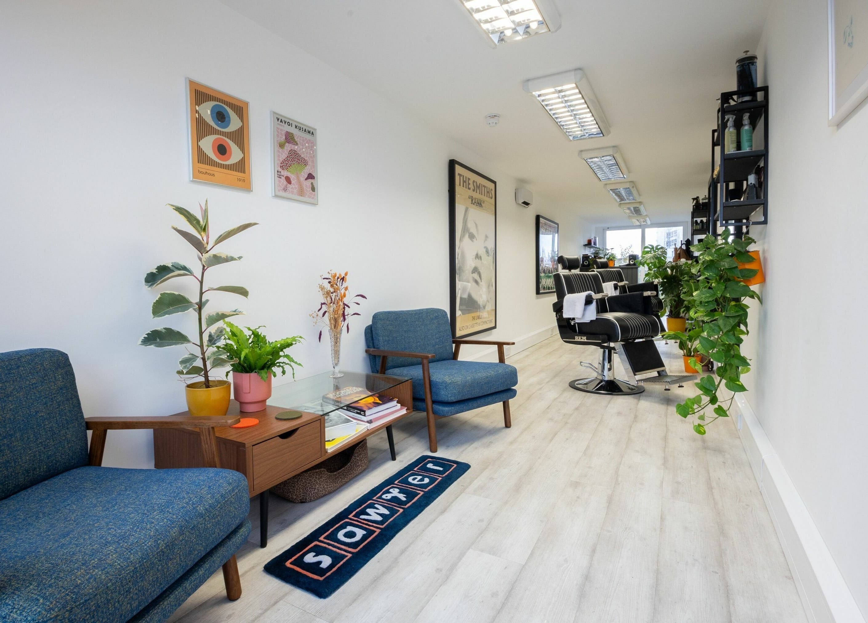 Modern interior of Sawyer salon in London, England, GB with stylish chairs and vibrant plants.