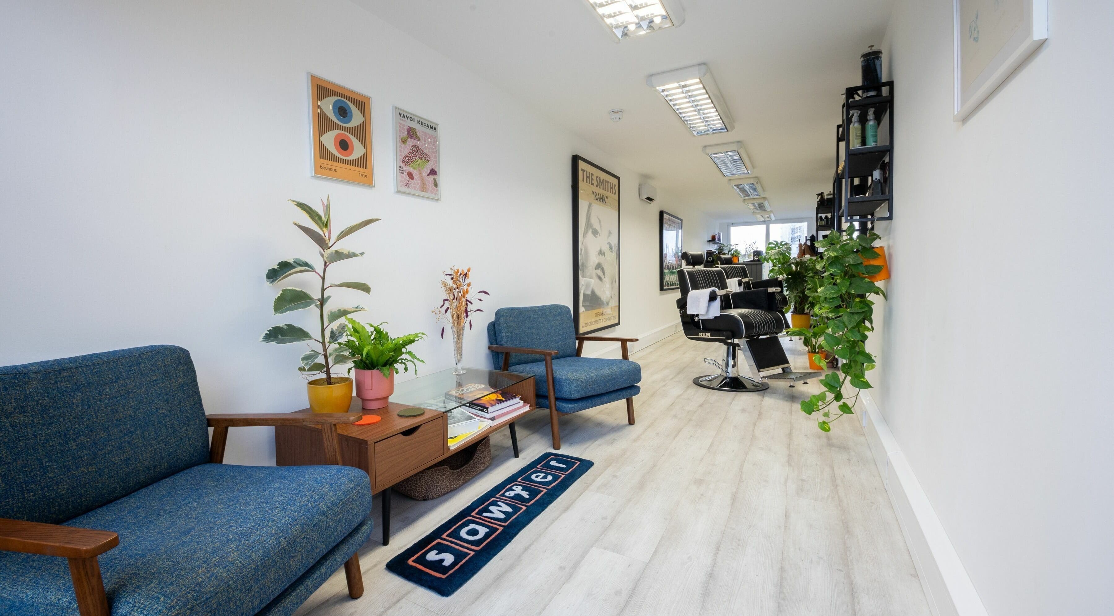 Modern interior of Sawyer salon in London, England, GB with stylish chairs and vibrant plants.