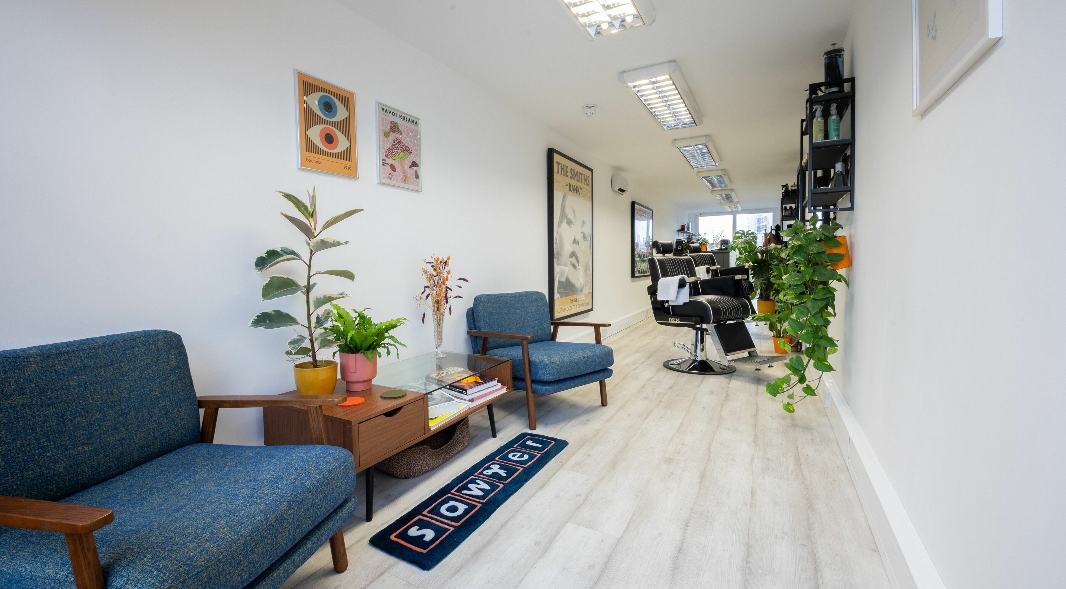 Modern interior of Sawyer salon in London, England, GB with stylish chairs and vibrant plants.