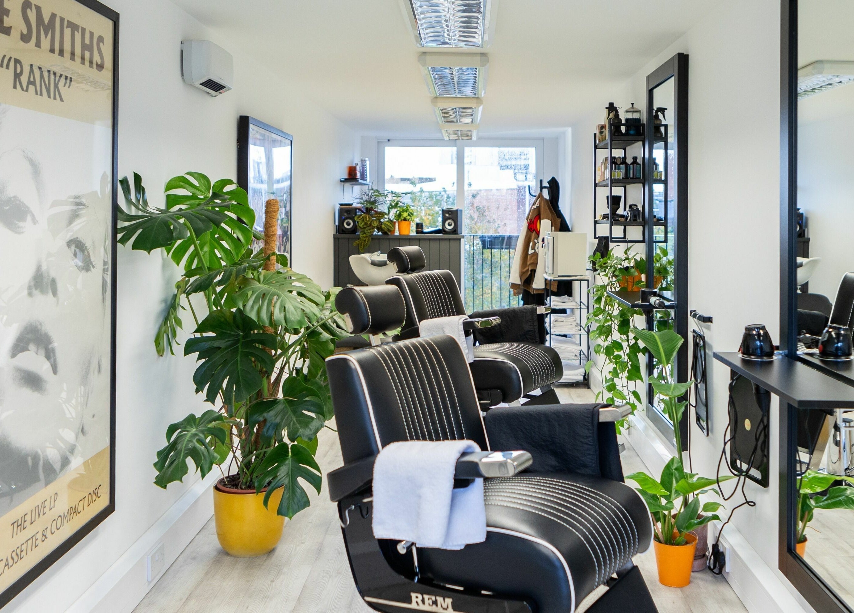 Modern barber chairs and plants at Sawyer, a trendy salon in London, England, GB.