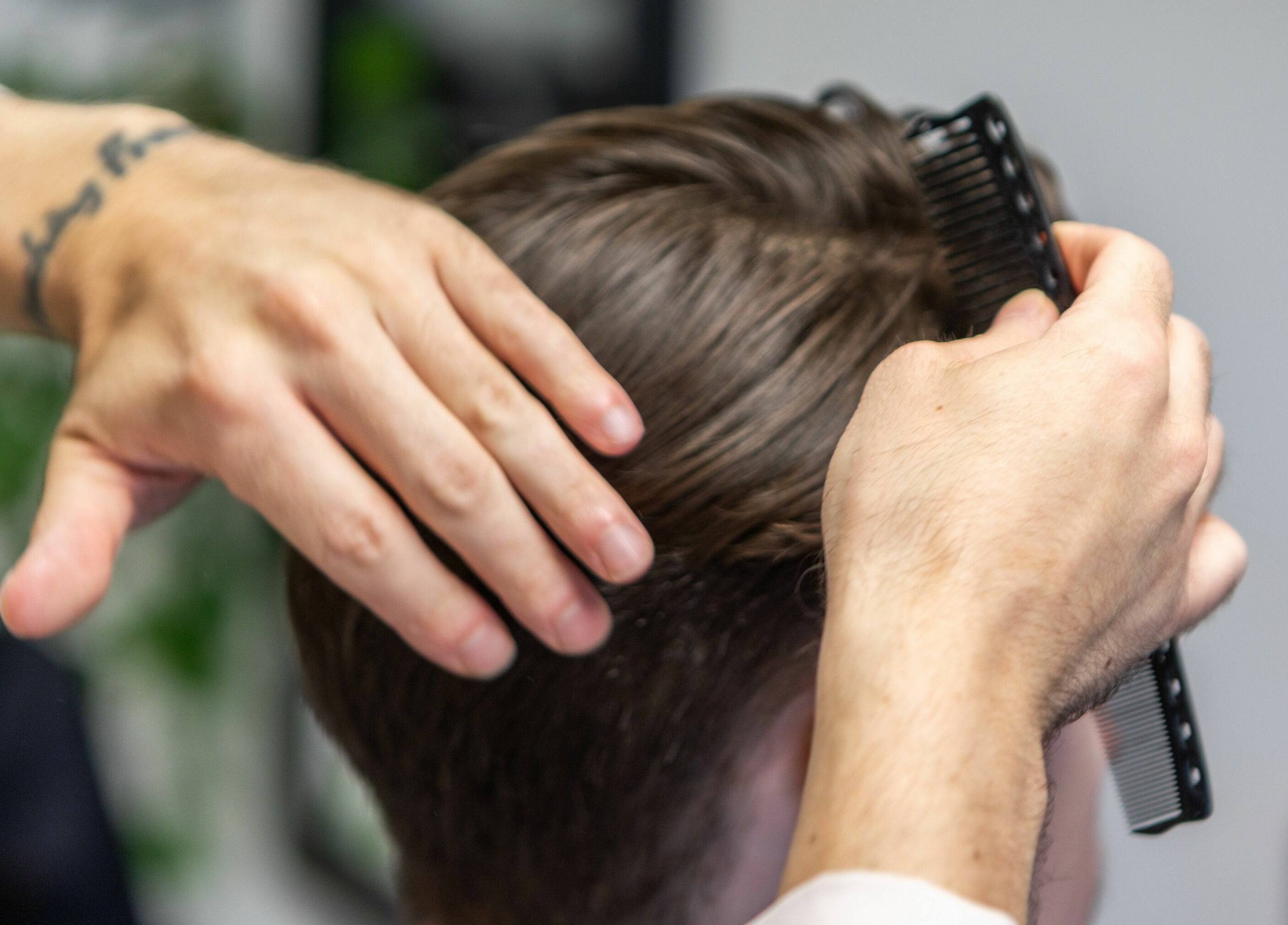 Hair stylist combing client's hair at Sawyer, London, England, GB.