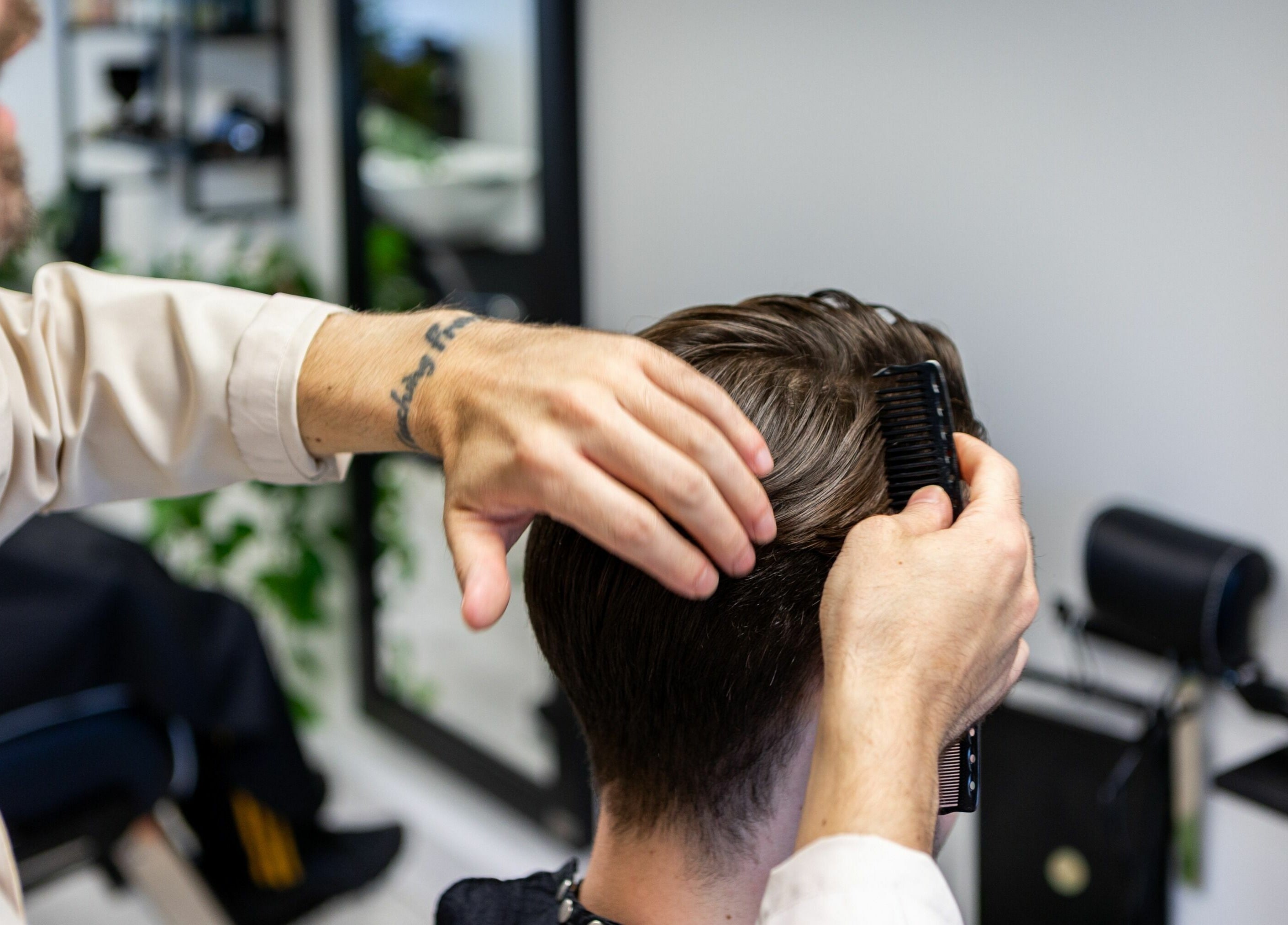 Stylist perfecting a haircut at Sawyer salon in London, England, GB with meticulous care and precision.
