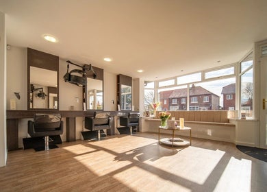 Bright, modern interior of Salon No.7 in Lytham St Annes, England, GB with stylish seating and large windows.