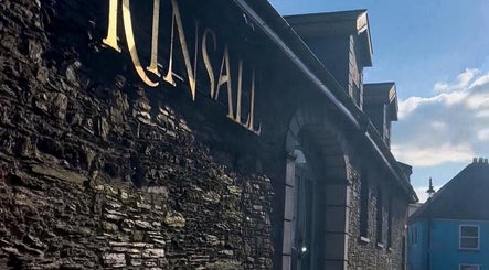 Historic stone building near Sophia’s Beauty Room in Kinsale, County Cork, IE with blue sky backdrop.