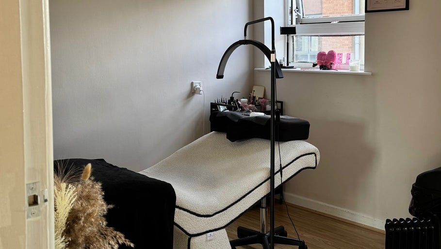 Relaxing treatment room at Enhance Studios, Christchurch, GB, featuring a comfortable bed and soothing decor.