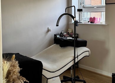 Relaxing treatment room at Enhance Studios, Christchurch, GB, featuring a comfortable bed and soothing decor.