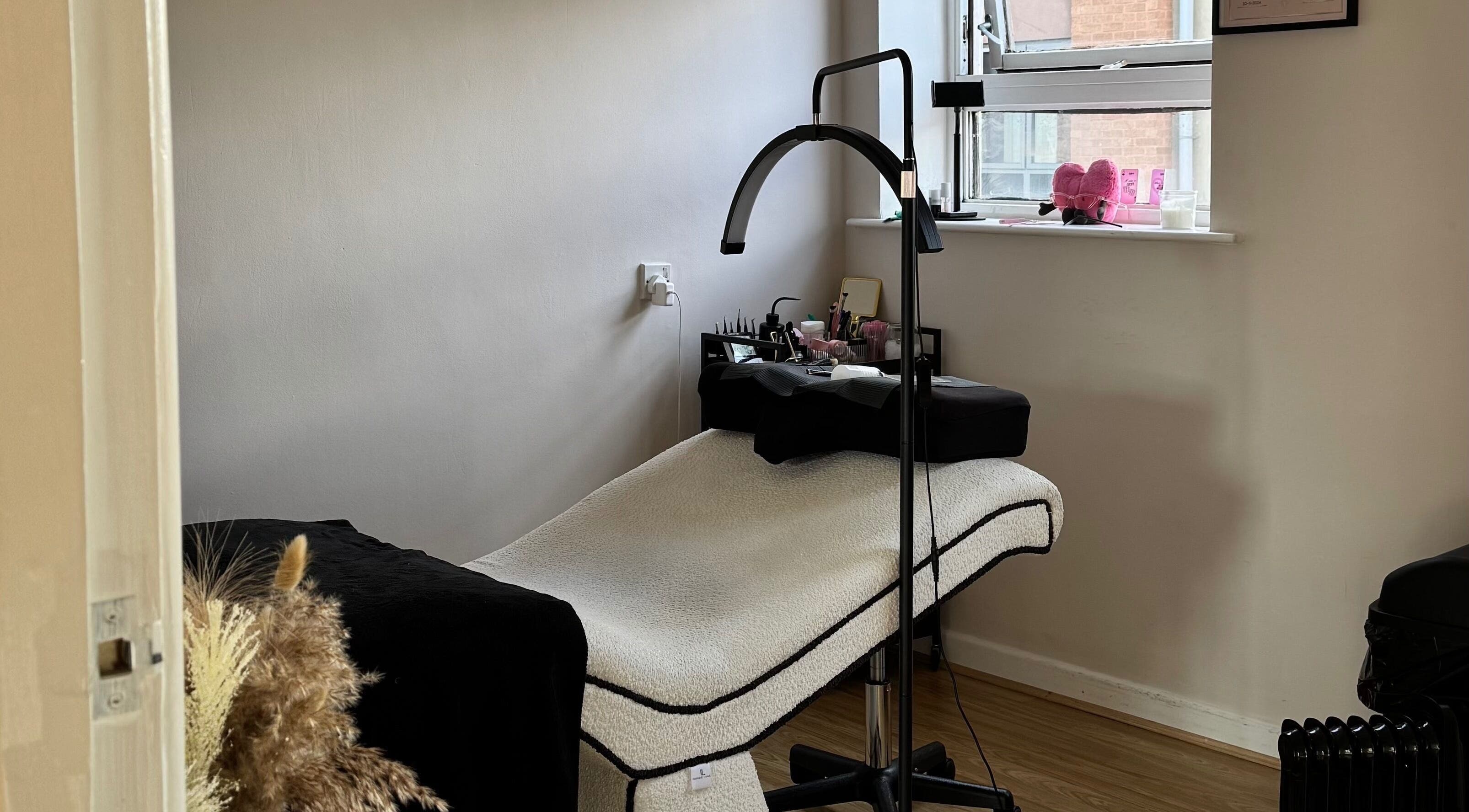 Cozy treatment room at Enhance Studios | By Han in Christchurch, GB with a comfortable bed and ambient decor.