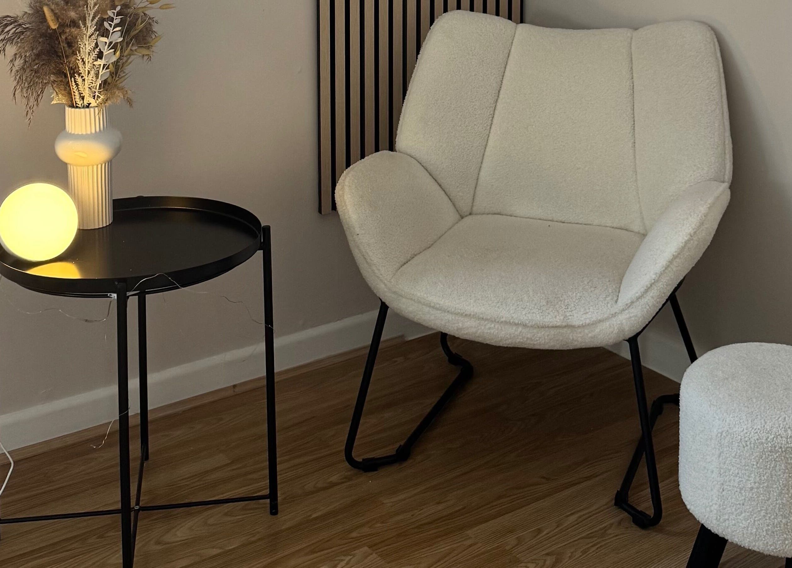 Elegant lounge chair setup at Enhance Studios | By Han, Christchurch, GB. Modern decor with soft lighting.