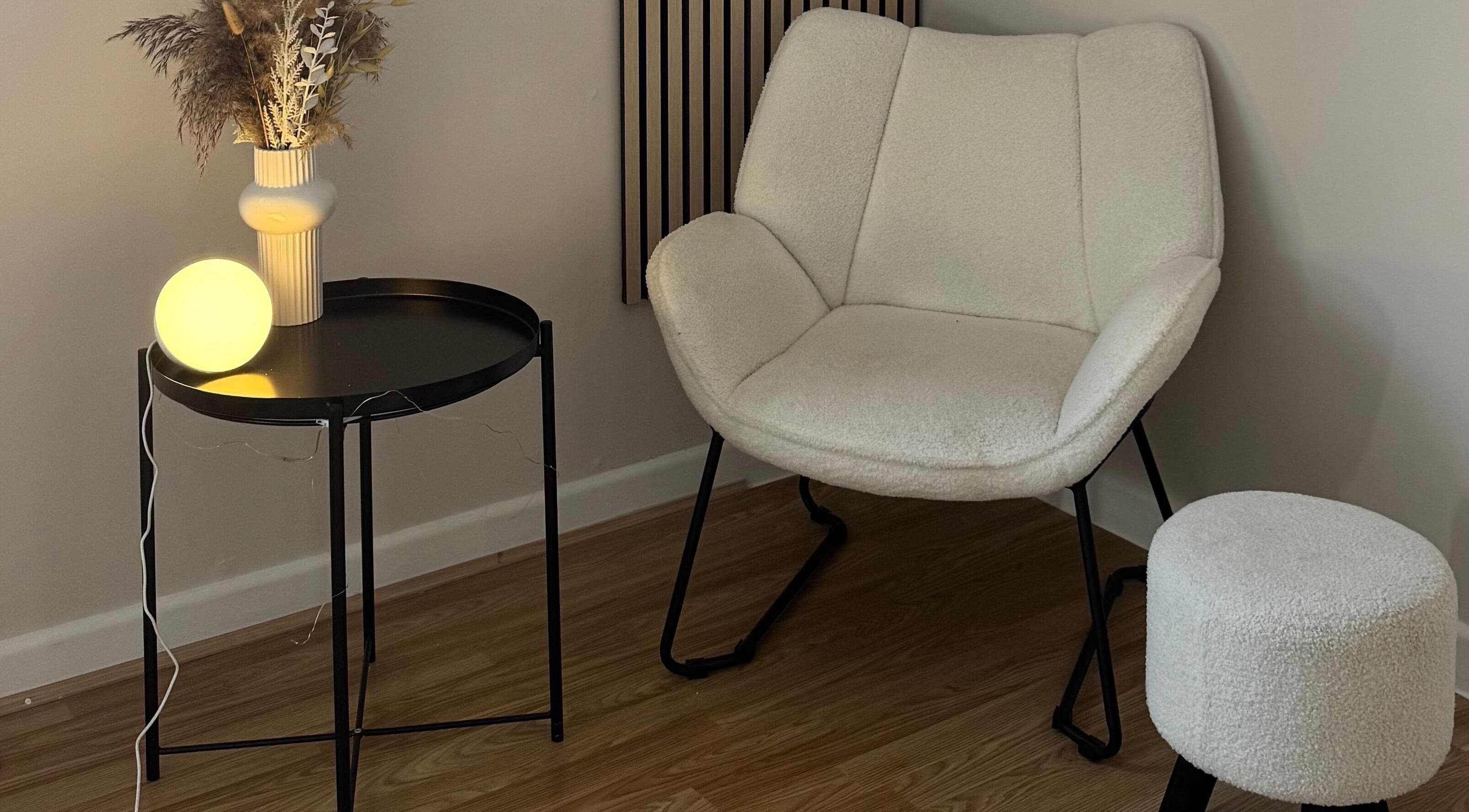 Elegant lounge chair setup at Enhance Studios | By Han, Christchurch, GB. Modern decor with soft lighting.