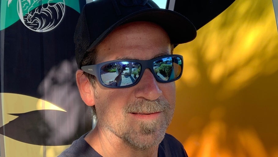Brian @ Twelve Stone’s Salon in Fresno, California, US, with reflective sunglasses and abstract backdrop.