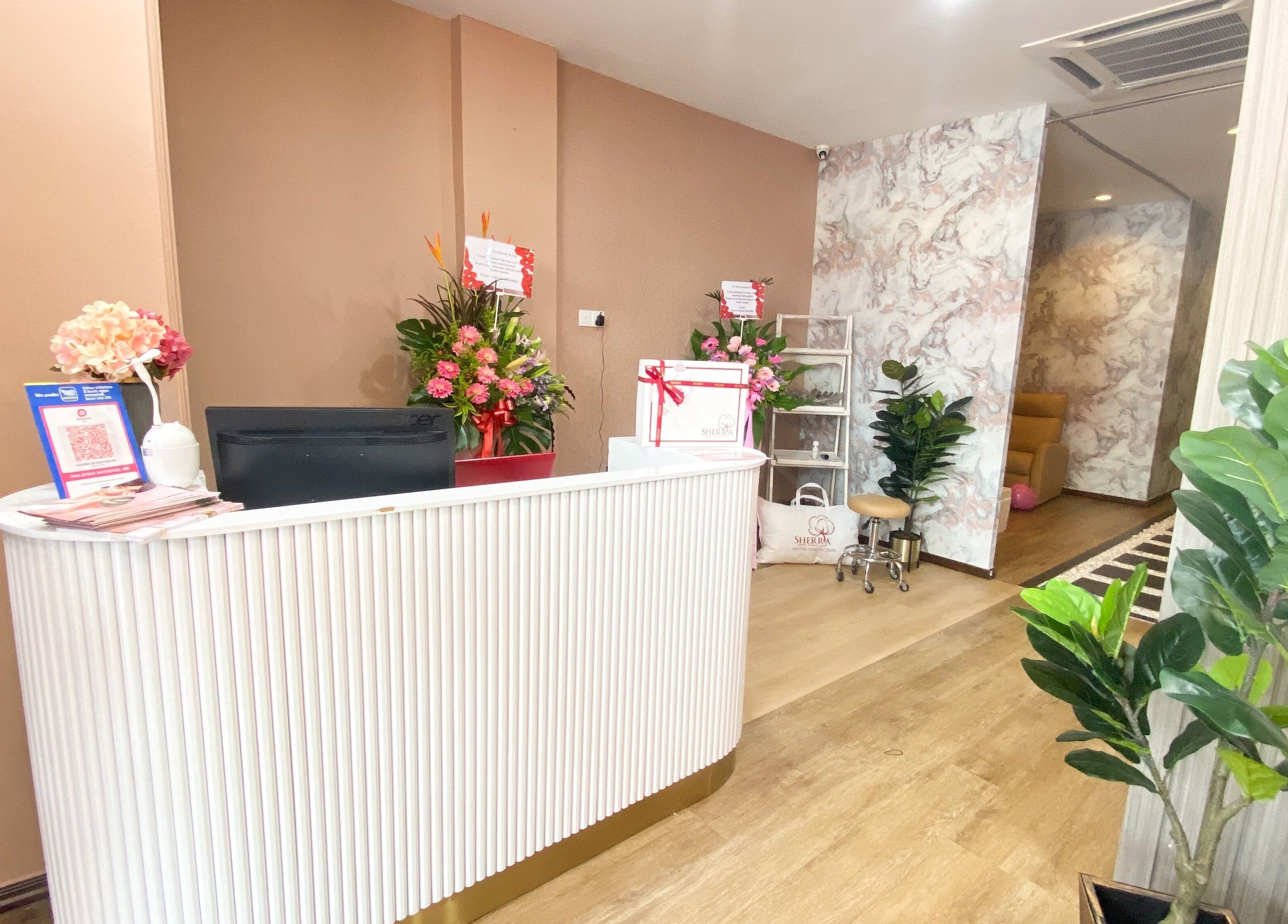 Reception area of Hera Beaute Spa in Nilai, Negeri Sembilan, MY, featuring a stylish white desk and vibrant flowers.