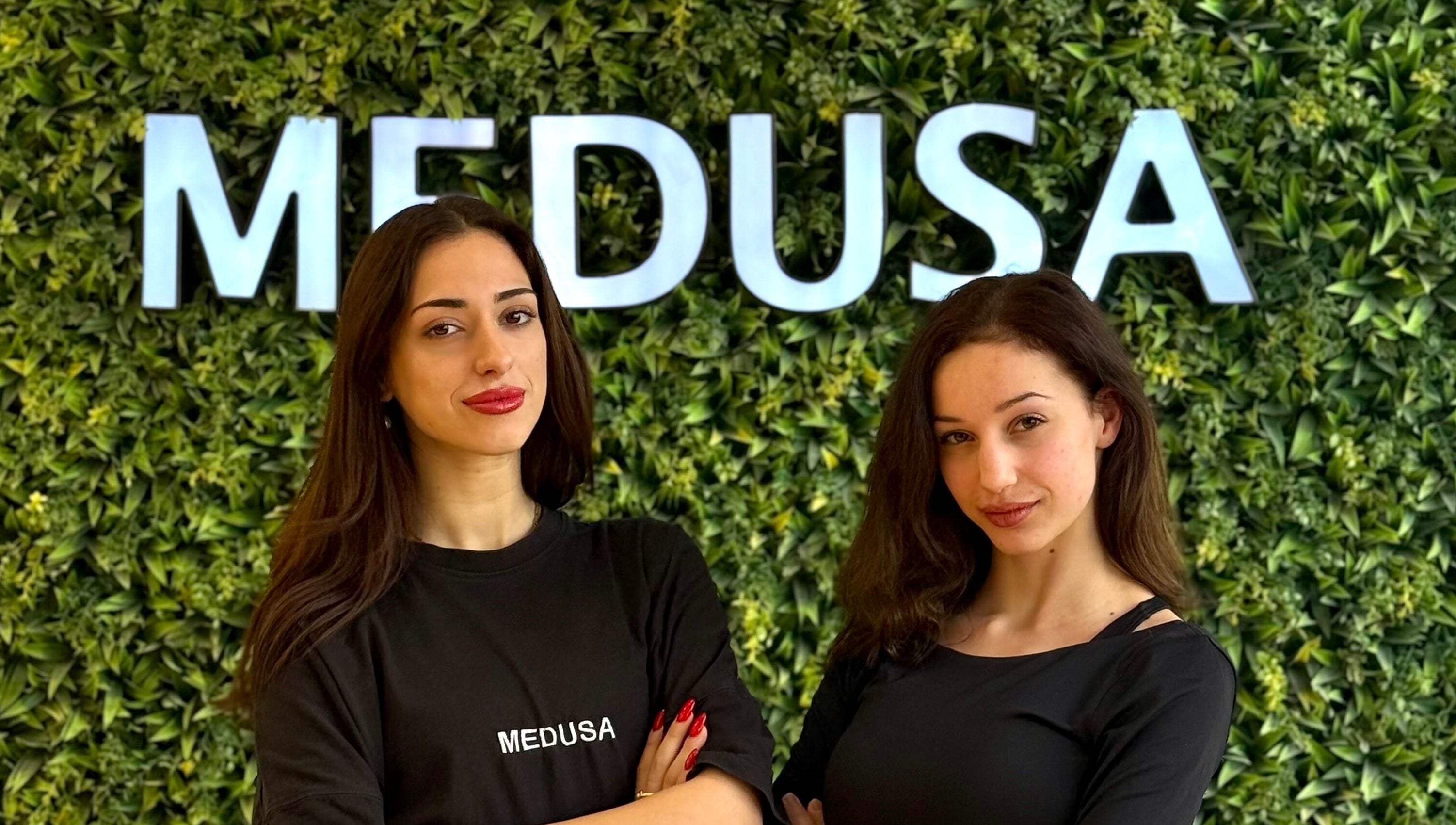 Δύο υπάλληλοι στο Medusa Barber Delfon στη Θεσσαλονίκη, GR, με φόντο πράσινο τοίχο.