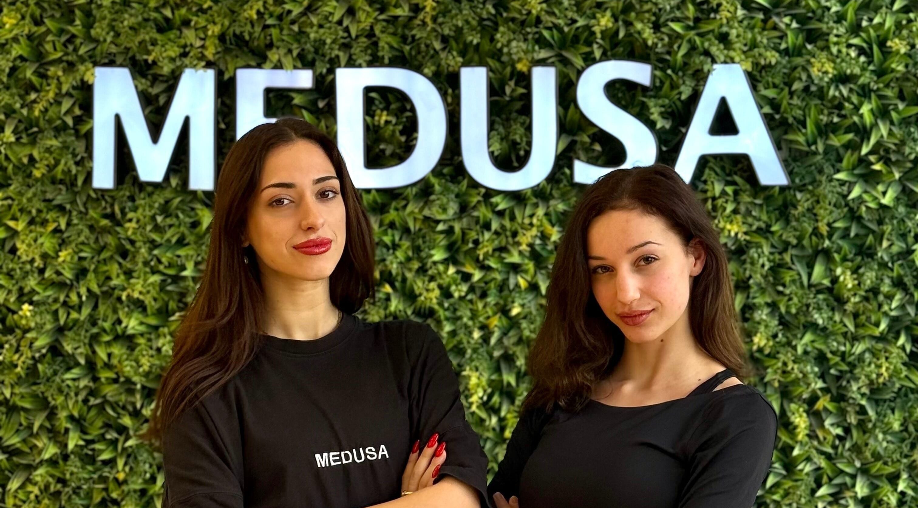 Δύο υπάλληλοι στο Medusa Barber Delfon στη Θεσσαλονίκη, GR, με φόντο πράσινο τοίχο.