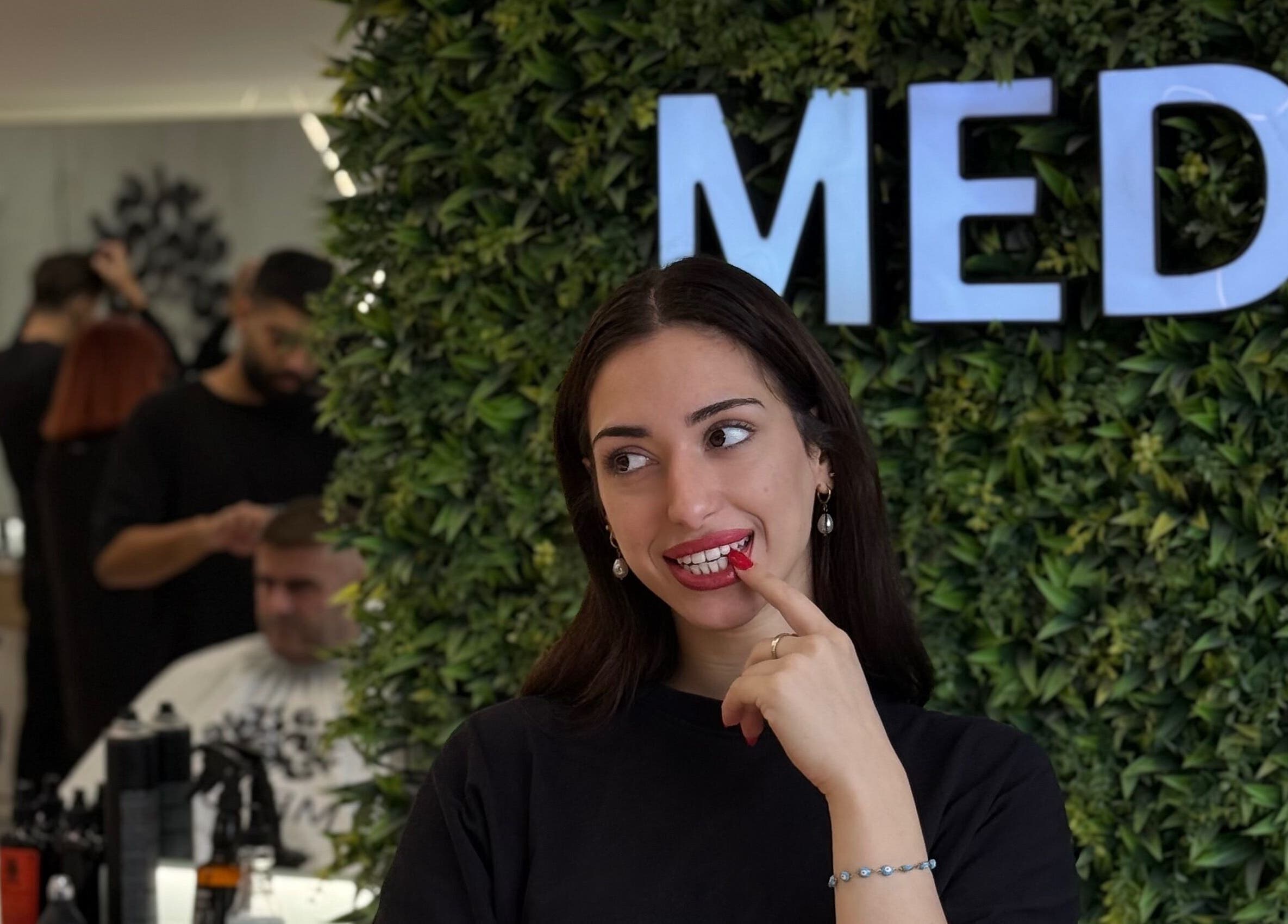 Μοντέρνα γυναίκα στο Medusa Barber Delfon, Θεσσαλονίκη, GR, σε πράσινο φόντο.