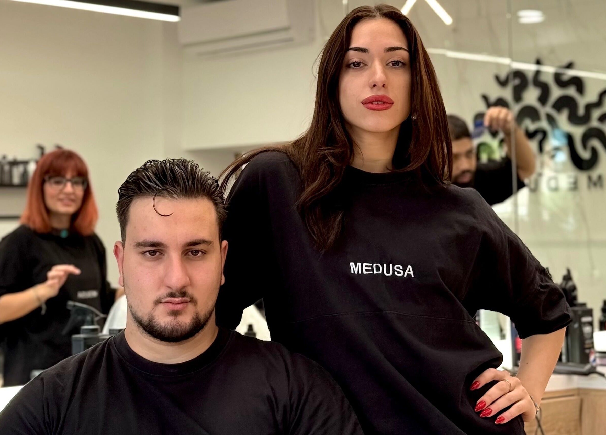 Στυλίστες στο Medusa Barber Delfon, Θεσσαλονίκη, GR με φόντο την κομψή διακόσμηση του χώρου.