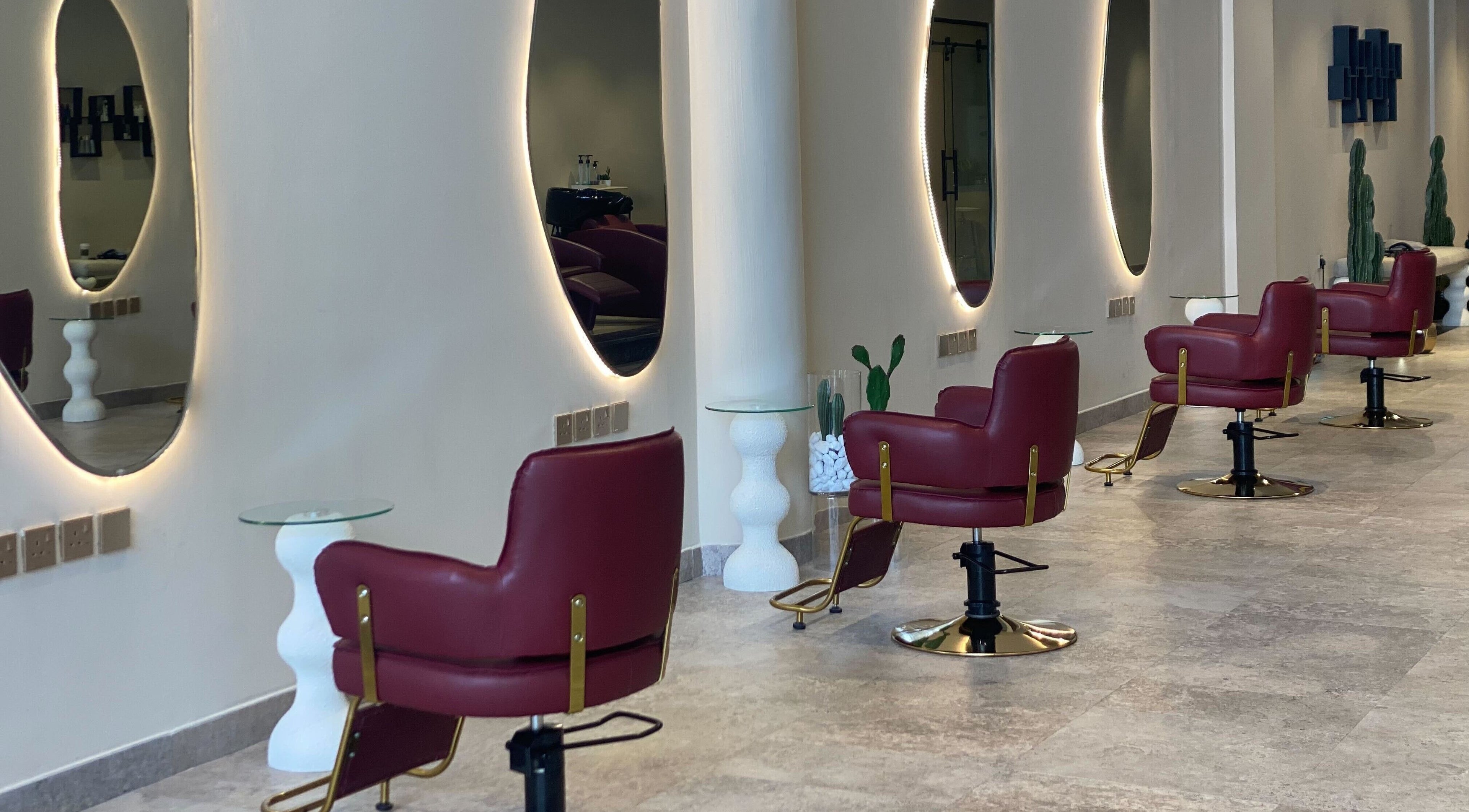 Stylish red salon chairs at Hairitage Salon, Riyadh, SA showcasing modern interior design.