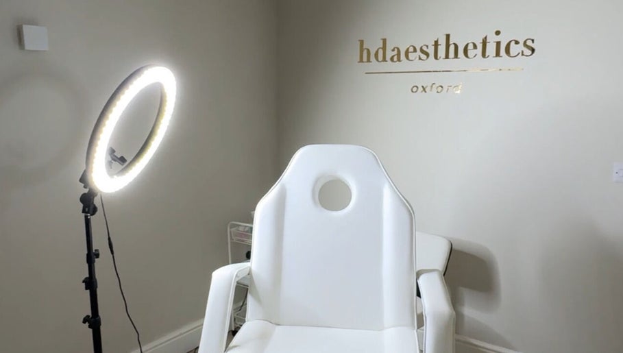 A modern treatment room at HD Aesthetics Oxford in Kidlington, England, GB with a sleek white chair and ring light.