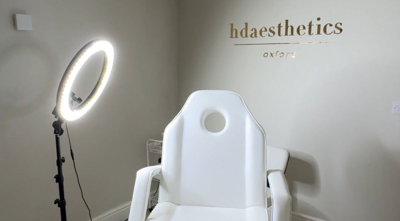 A modern treatment room at HD Aesthetics Oxford in Kidlington, England, GB with a sleek white chair and ring light.