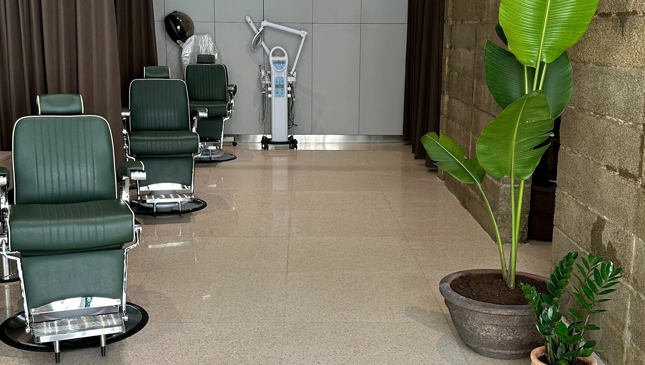 Elegant barber chairs at Float Barbershop, Sharjah, Sharjah, AE, surrounded by green plants for a relaxing vibe.