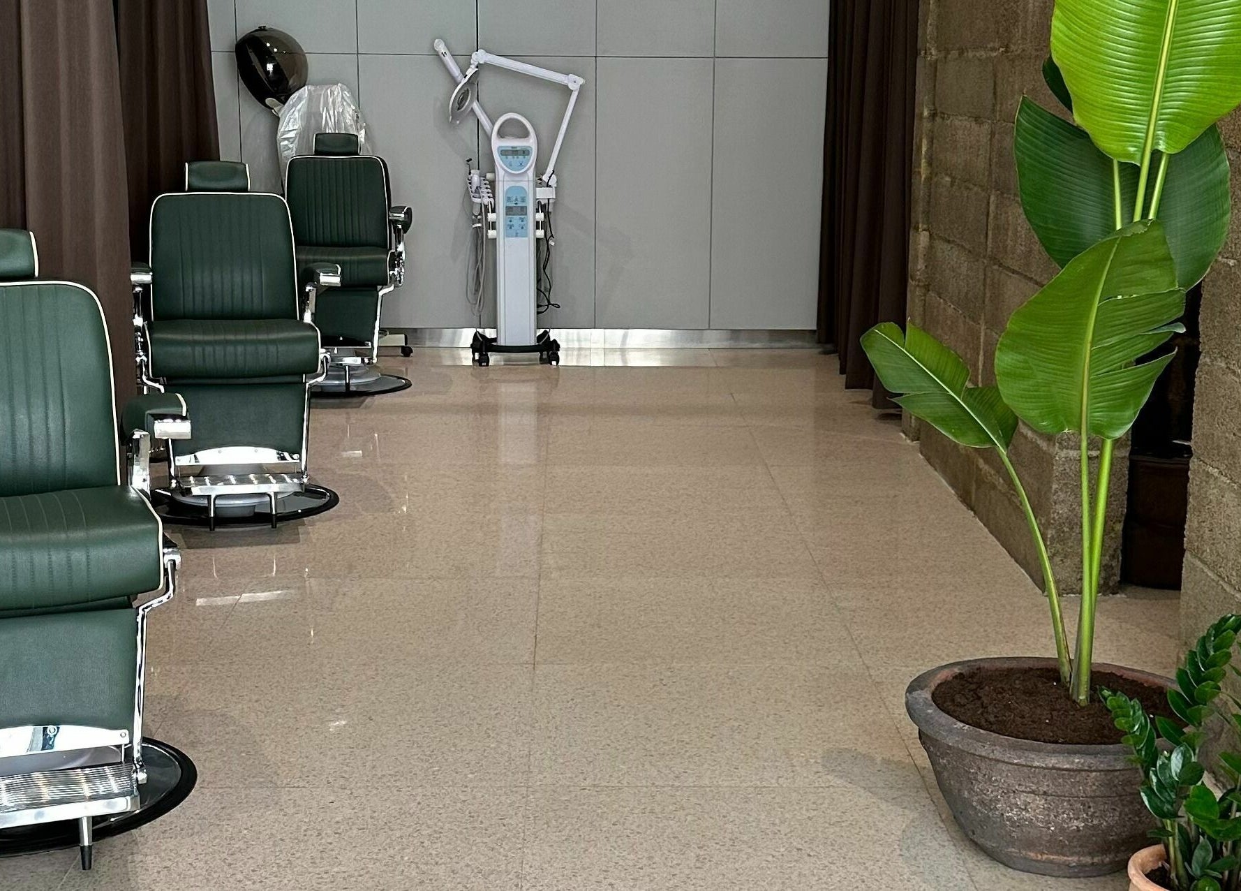 Elegant barber chairs at Float Barbershop, Sharjah, Sharjah, AE, surrounded by green plants for a relaxing vibe.