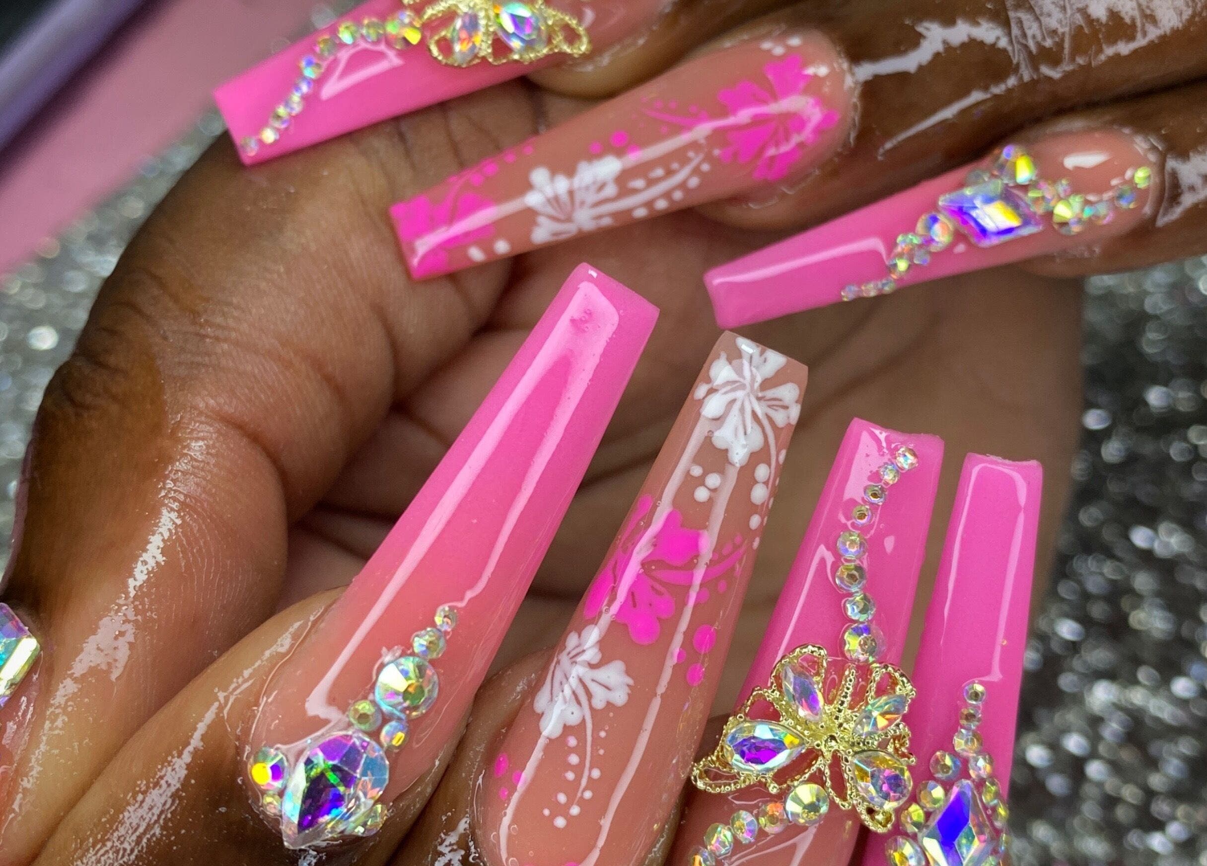 Beautiful pink acrylic nails with intricate designs at K’ Oari Nail Artistry, Potters Village, Saint John, AG.