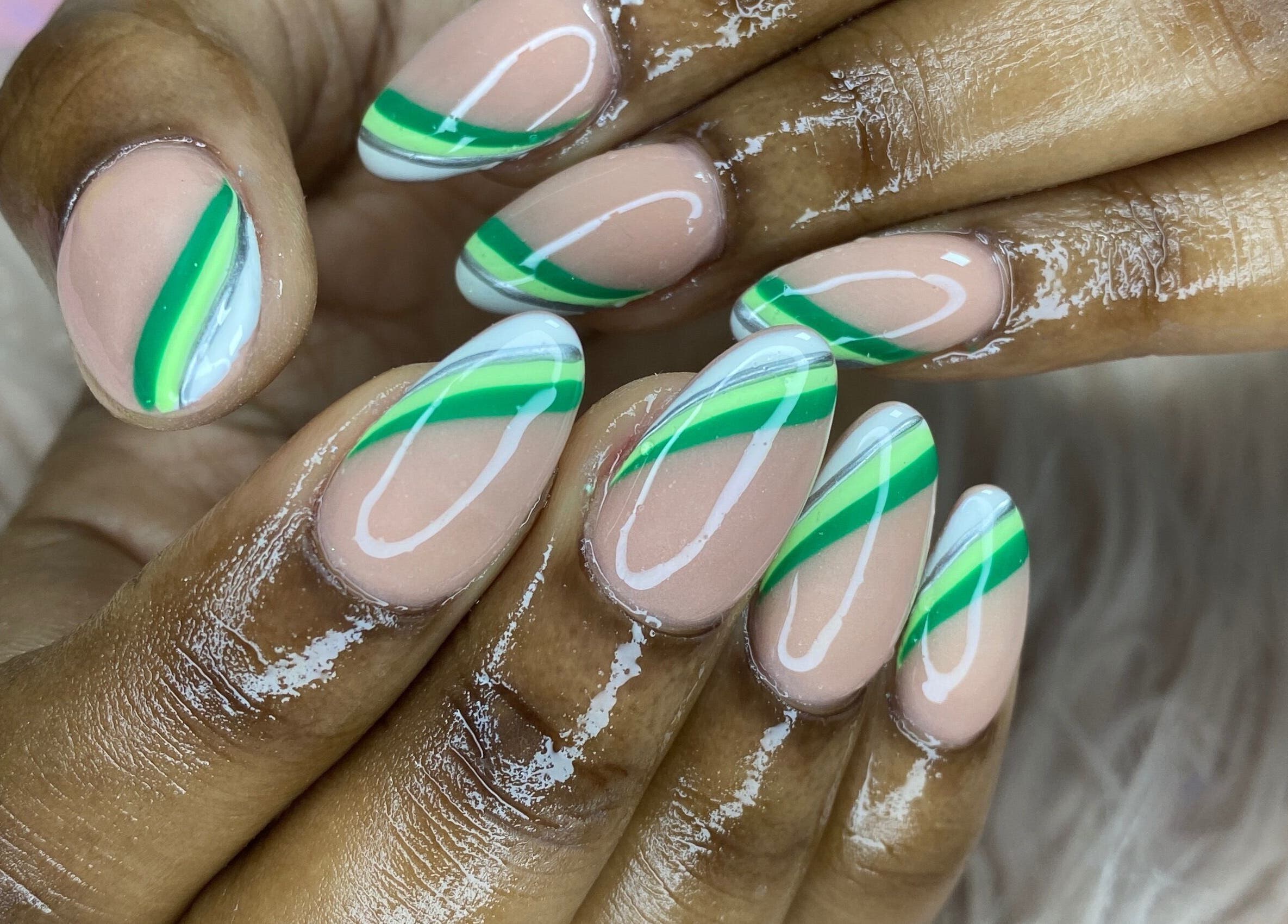 Almond-shaped nails with green stripes by K’ Oari Nail Artistry in Potters Village, Saint John, AG.